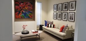 Sitting room, colourful sitting room, colourful family room, oval coffee table, marble coffee table, custom joinery, colourful cushions, wall art, black and white photos, photo wall