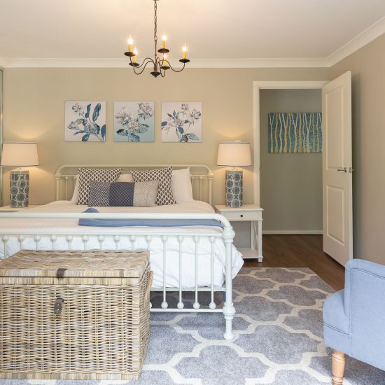Hamptons style, Hamptons bedroom, iron bed, white iron bed, Hamptons chandelier, iron chandelier, bedside lamps, Hamptons lamps, bedroom floor rug, cane chest
