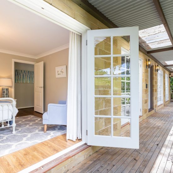 Front verandah, Hamptons style, Hamptons bedroom, iron bed, white iron bed, bedroom floor rug, French doors, white curtains, sheer curtains