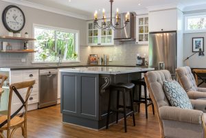 Contact us for an initial consultationHamptons kitchen, Hamptons style, chandelier over island, iron chandelier, shaker cabinet doors, calacutta stone benchtop, panelled glass cabinet doors, engineered timber floor, subway tiles, grey subway tiles